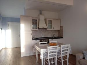 a kitchen with a table and chairs in a room at Appartamento Leccino con piscina - Riva Trigoso in Sestri Levante