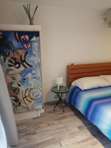 una camera da letto con un letto e un dipinto sul muro di Fiore Di Loto a Matera