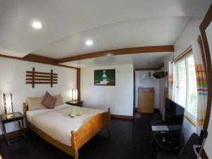 a bedroom with a bed and a television in it at Kesa Cloud 9 Hotel & Resort Siargao in General Luna