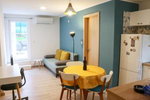 a kitchen and living room with a table and a couch at Velin Apartment in Split