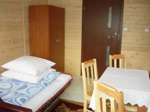 弗瓦迪斯瓦沃沃的住宿－Domki Sara，配有一张床和一张桌子及椅子的房间