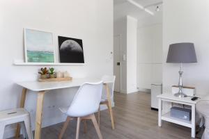 a white dining room with a table and chairs at Apartamento modeno e acolhedor com terraço in Montijo