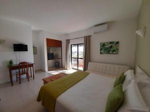 a bedroom with a large white bed and a desk at Casa Rosa Montes in Luz