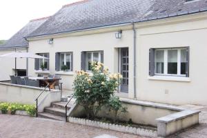 a white house with a table and a plant at Country house - La Mercerie in Continvoir