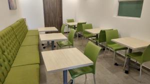 a classroom with green chairs and tables and a chalkboard at Hotel Casa Nico in Barranquilla
