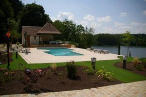 a pool with a gazebo next to a lake at Chateau de Vau Rozet in Continvoir