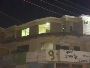 a large white building with a sign on it at night at Adala Motel in Meru