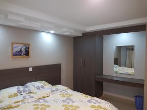 een slaapkamer met een bed en een grote spiegel bij Adala Motel in Meru