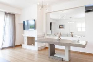a living room with a table and a large mirror at New Luxury Apartment in Glyfada with pool in Athens