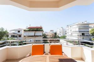 two orange chairs sitting on top of a balcony at New Luxury Apartment in Glyfada with pool in Athens