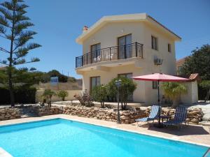 une villa avec une piscine et une maison dans l'établissement Kapsalia Holiday Villas, à Pissoúri