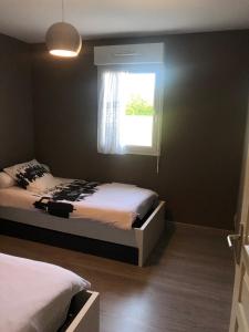 - une chambre avec 2 lits et une fenêtre dans l'établissement pavillon individuel, à Cricqueville-en-Bessin