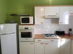 a kitchen with white appliances and a white refrigerator at pavillon individuel in Cricqueville-en-Bessin