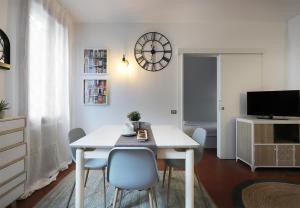 een eetkamer met een tafel, stoelen en een klok bij Yourbanflat Appiani in Padua