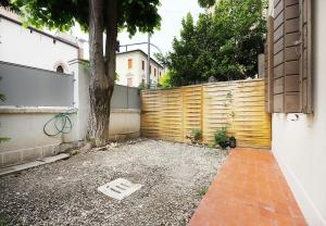 een houten hek met een boom op een binnenplaats bij Yourbanflat Appiani in Padua