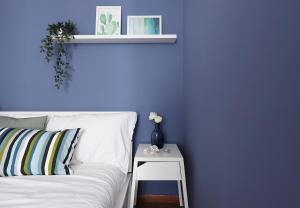 een blauwe slaapkamer met een wit bed en een bijzettafel bij Yourbanflat Appiani in Padua