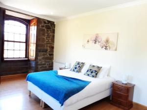 a bedroom with a bed with a blue blanket at Quinta do Salgueiral in Peso da Régua