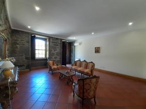 a living room with chairs and a couch and a table at Quinta do Salgueiral in Peso da Régua