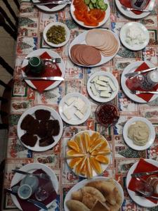 einen Tisch mit Teller mit Lebensmitteln auf einem Tisch in der Unterkunft Cana Wedding Guest House in Kafr Kannā