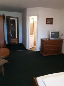 Cette chambre comprend un lit et une télévision sur une commode. dans l'établissement Westmotelrestaurant, à Pădurea Urziceni