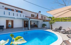 een villa met een zwembad en een huis bij Villa Zlata in Krk