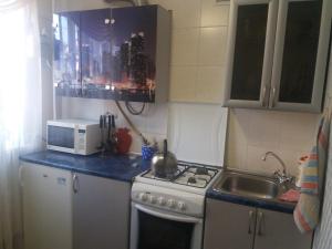 een keuken met een wastafel, een fornuis en een magnetron bij Apartment Akademika Krilova 7 in Sevastopol