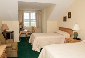 una camera d'albergo con due letti e una sedia di Smithfield Station a Smithfield Altre 36 foto