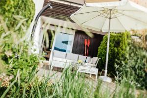 a patio with an umbrella and chairs and a table and an umbrella at Appartement am See in Lamperstätten +3 photos