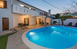 een zwembad voor een huis bij Villa Zlata in Krk