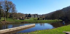 a large house with a river in front of it at Les Gites Audrain in Plussulien