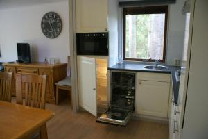 a kitchen with an open oven with a sink at t'Bakkersboschje nummer 8 in Putten +17 photos