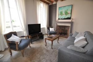 salon z kanapą, krzesłami i telewizorem w obiekcie Gite Les Robins w mieście Rebourseaux