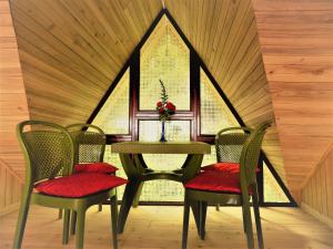 a table and chairs in a room with a window at Saino ADKD Homestay Darjeeling in Darjeeling