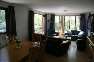 a living room with a couch and a table at t'Bakkersboschje nummer 8 in Putten