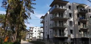 an apartment building with balconies on a street at Porta Mare Apartamenty Leśne Tarasy II in Dziwnówek