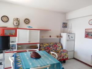 a living room with a table and a refrigerator at Terrace on the sea in Roccalumera