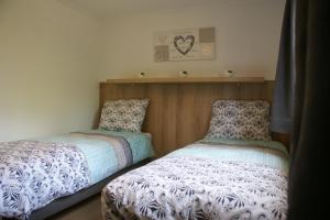 two beds sitting next to each other in a bedroom at t'Bakkersboschje nummer 8 in Putten