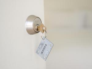 a key tag hanging from a door knob at The Madison Fire Island Pines in Fire Island Pines +10 photos
