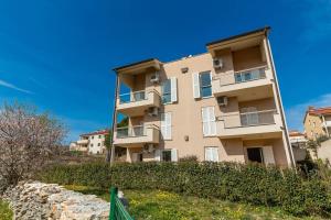 wysoki budynek apartamentowy z niebieskim niebem w obiekcie Apartment Punta Premantura E with garden w mieście Premantura