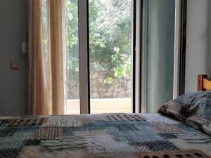 a bedroom with a bed and a large window at Majia 2 bedroom apartment in Gerani