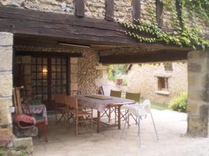 a patio with a table and chairs in front of a building at Le Moulin de Monternault in Montreuil-le-Henri