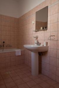 y baño con lavabo, bañera y espejo. en Guesthouse Monopati - Ξενώνας Μονοπάτι, en Lechovo