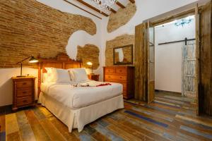 - une chambre avec un lit et un mur en briques dans l'établissement Noah House city center - Historic center, à Cadix