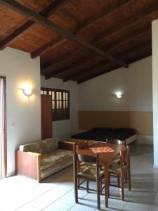 a living room with a table and a couch and a bed at Dourada Studios in Santa Maria