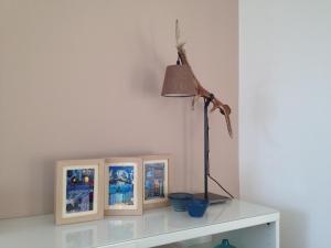 a lamp on a white table with two pictures at Sunny Apartment in Innsbruck