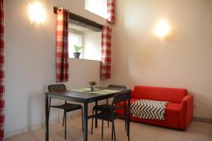 a dining room with a table and a red couch at Le Grehando in Le Guerno