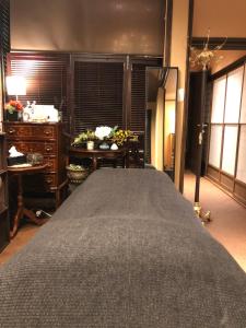 een slaapkamer met een groot bed en een dressoir bij Guest House "Ro"kumano in Shimonoseki