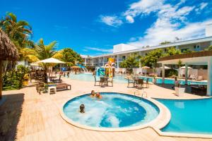 a pool at a resort with people in it at Portal Beach - Rede Soberano in Porto Seguro