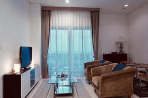 un soggiorno con divano, TV e finestra di Lucky Tower Residence 2BR Top Floor Condo a Giacarta