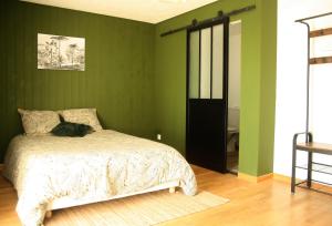 a bedroom with green walls and a bed with a cat on it at Le clos Darwin - chambres d'hôtes in Brin-sur-Seille